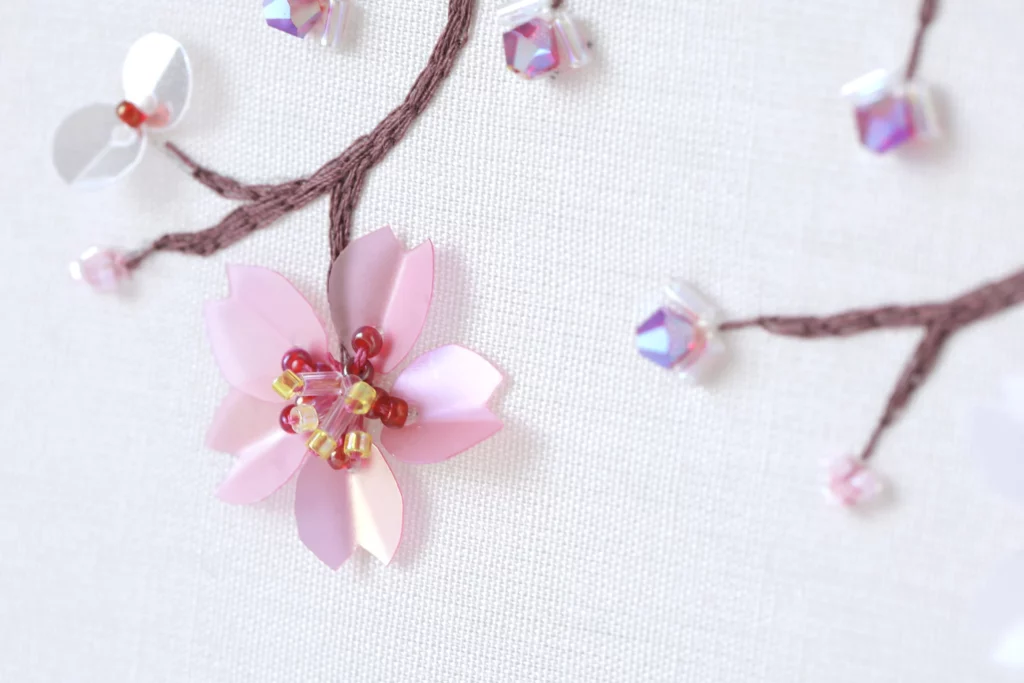 Cherry blossom embroidery in an embroidery frame, showcasing an example of Haute Couture techniques to learn within the Delta V Creations video tutorials.