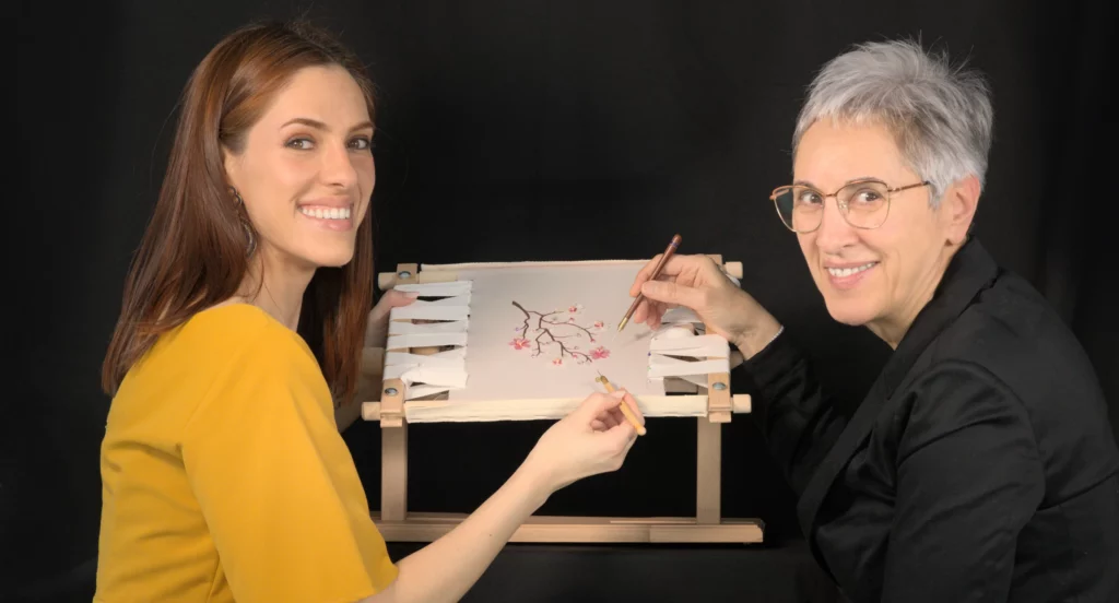 Laura S. Urbina, profesora de bordado, muestra a una alumna las técnicas de aguja y crochet de Luneville durante un taller práctico de bordado de alta costura.