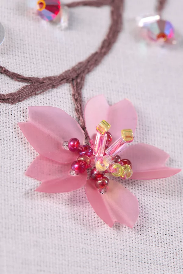 Macro shot of an embroidered sakura blossom, showcasing delicate Haute Couture embroidery techniques in stunning detail.