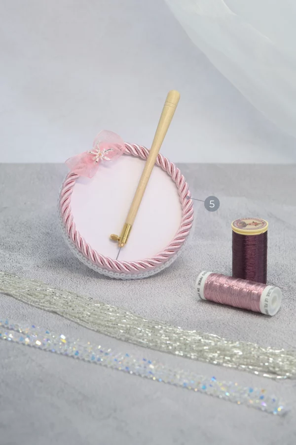 Light pink Starlight embroidery beading plate with Lunéville hook, metallic threads, beads, and crystals for precise embroidery work.