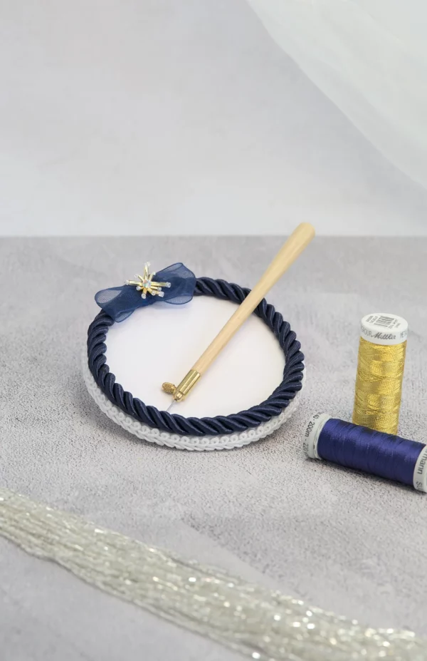 Pâté de broderie Haute Couture, outil essentiel pour la broderie de Lunéville, qui maintient les fournitures en place avec élégance et précision.