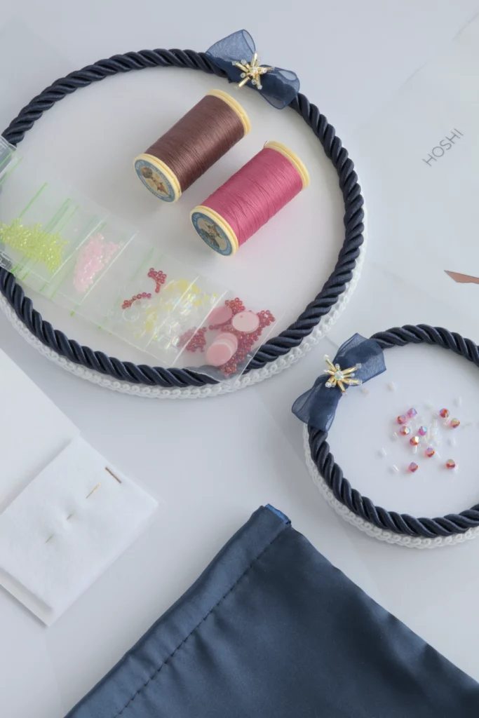 Flat lay of Hoshi embroidery kit with haute couture embroidery threads, beads and sequins to create 3D cherry blossom flower embellishments
