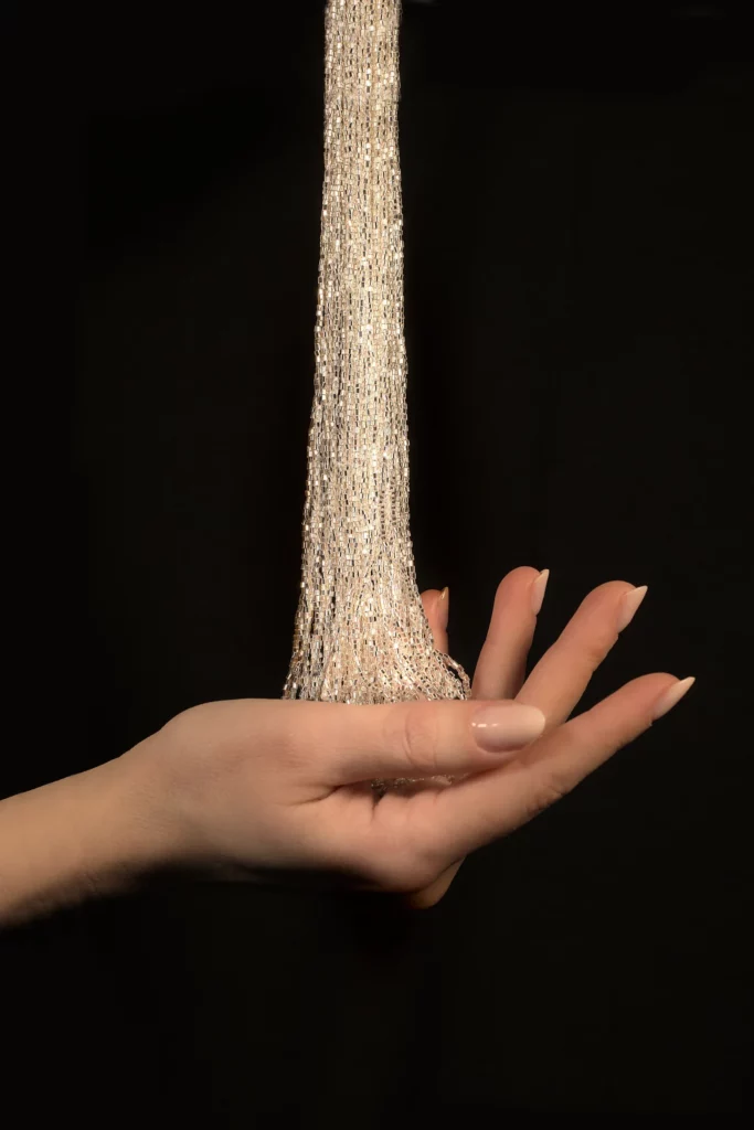 Élégantes fournitures de broderie d’Art et broderie Haute Couture tenues dans la main, mettant en valeur un savoir-faire exclusif avec des perles de cristal scintillantes.