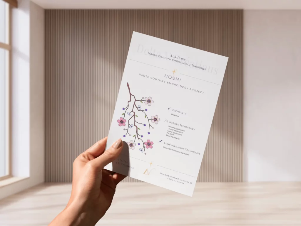 Hand holding a printed embroidery guide from an in-person workshop, summarizing key techniques for continued practice at home.