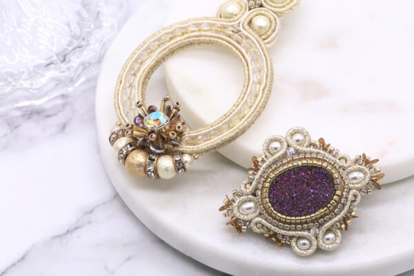 Broche dorado y violeta bordado a mano con piedra natural, perlas y trenza soutache