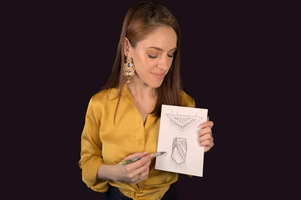 The embroidery artist from Delta V Créations sketches a future embroidery design while on a consultation call, marking the first step in creating a bespoke embroidery piece.