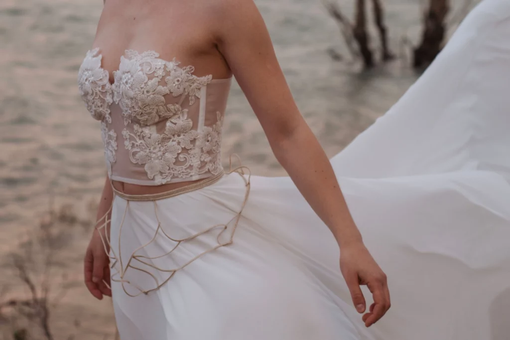 Close-up of a bridal gown featuring a gold embroidered belt with a romantic tribal design, adding elegance and personalization to the wedding dress.