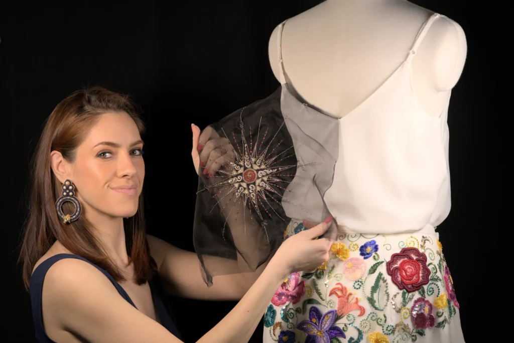 Gros plan d'une broderie appliquée sur un tissu, ajoutant un détail raffiné et artisanal à un vêtement terminé ou en cours de réalisation.
