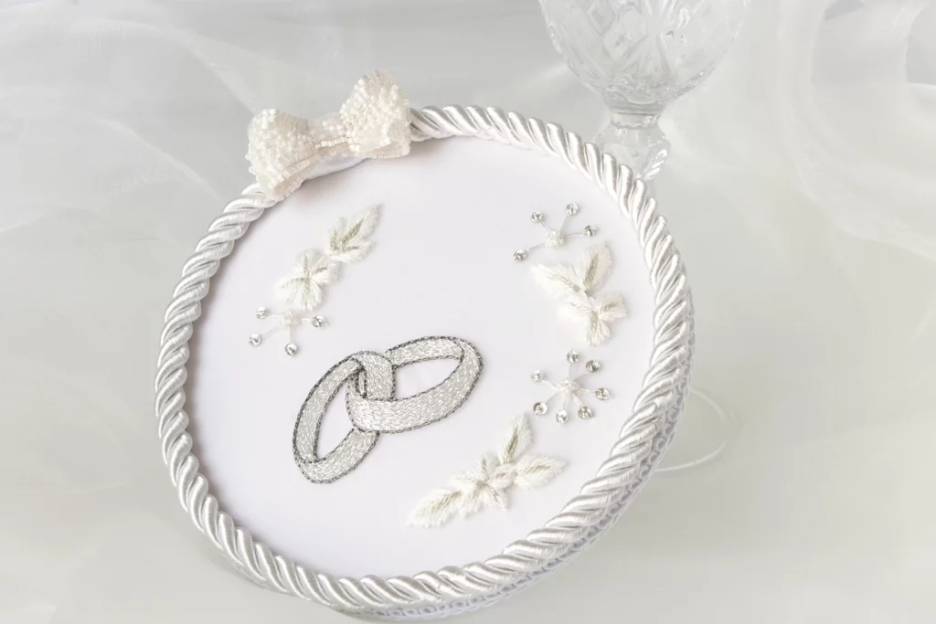 Elegant wedding ring holder with custom embroidery, personalized to match the bride's dress for a unique bridal keepsake.