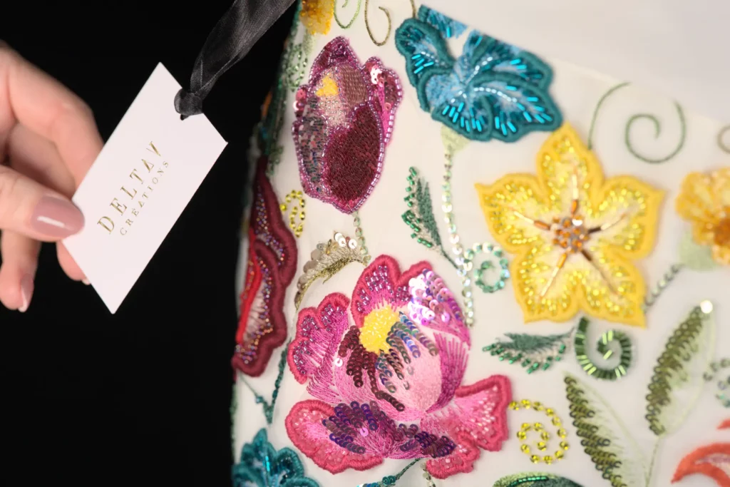 A macro shot of a vibrant hand-embroidered skirt with a price tag, illustrating bespoke embroidery pricing and craftsmanship.