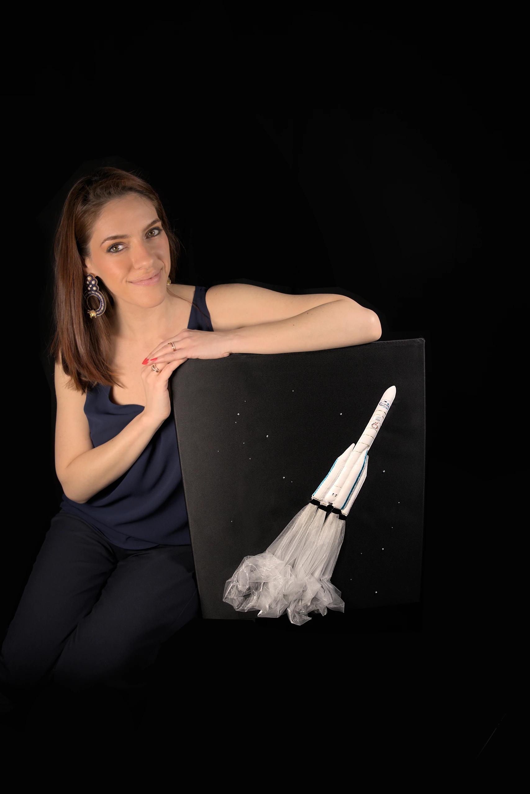 Laura S. Urbina holding a fully hand-embroidered artwork of the Ariane 6 rocket, showcasing bespoke embroidery and artistic textile design.