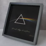 Hand-embroidered prism artwork showcasing light refraction, blending textile art with science-inspired creativity.