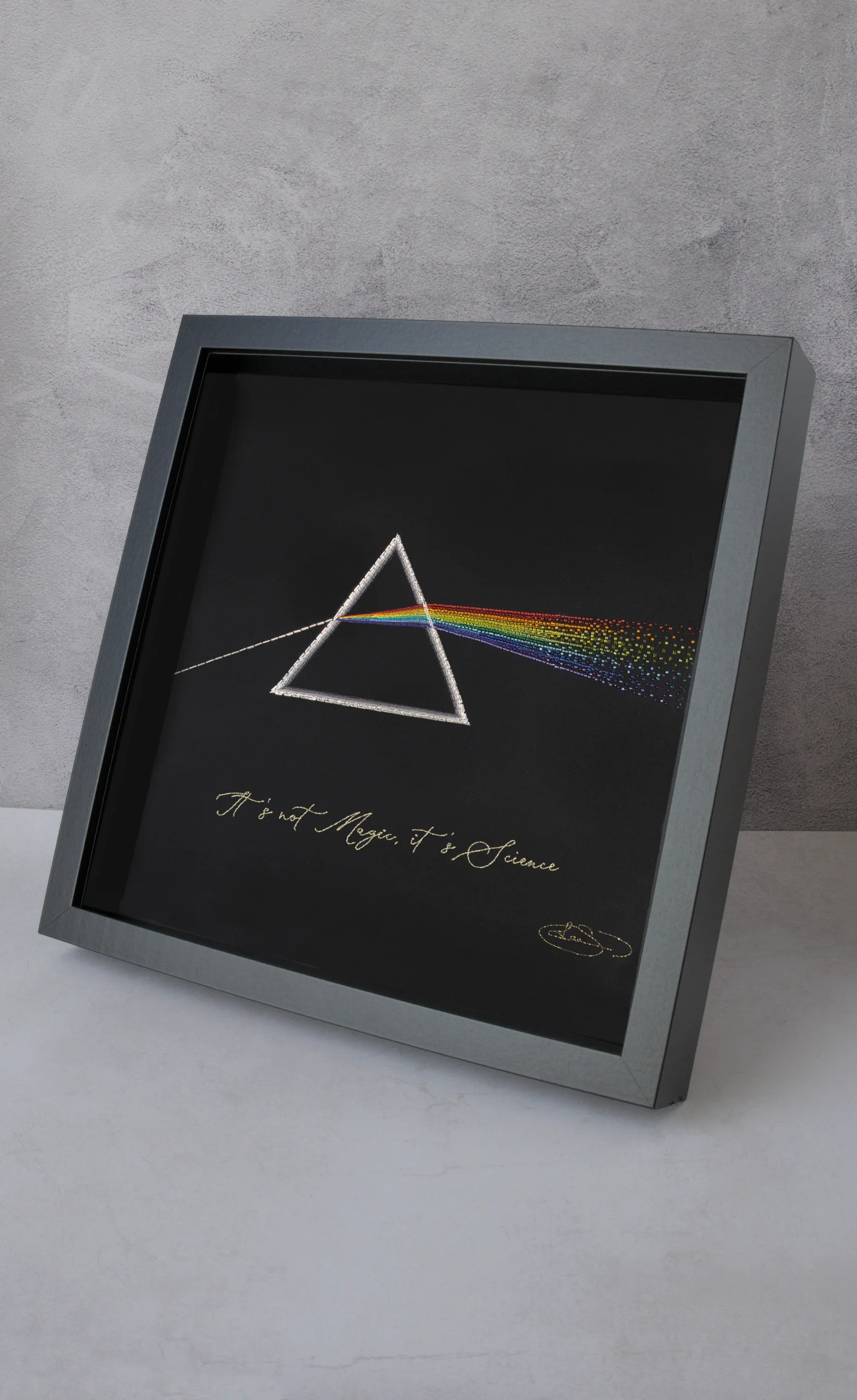 Hand-embroidered prism artwork showcasing light refraction, blending textile art with science-inspired creativity.