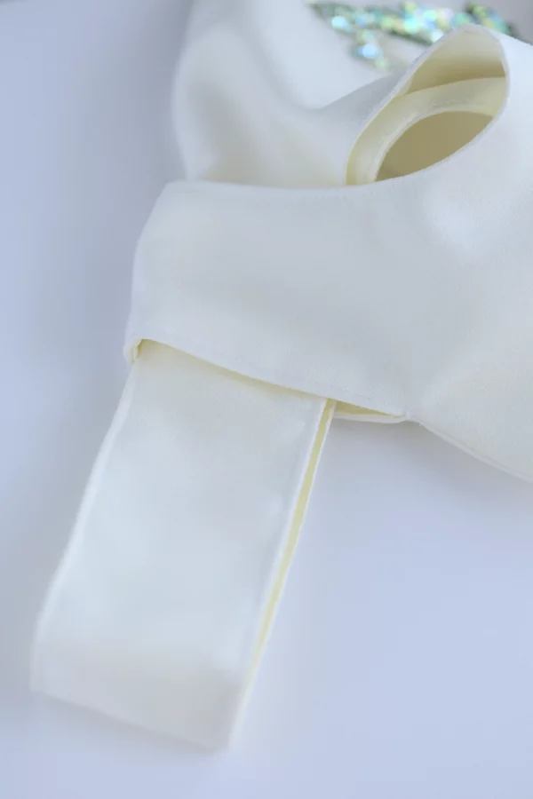 Detail of Carina bag’s Japanese knot handle closure, showing the unique interlocking design crafted in soft off-white crêpe fabric.