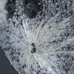 Close-up of hand-embroidered lunar surface with crystals, sequins and silver thread, revealing rich texture and luxurious detail.