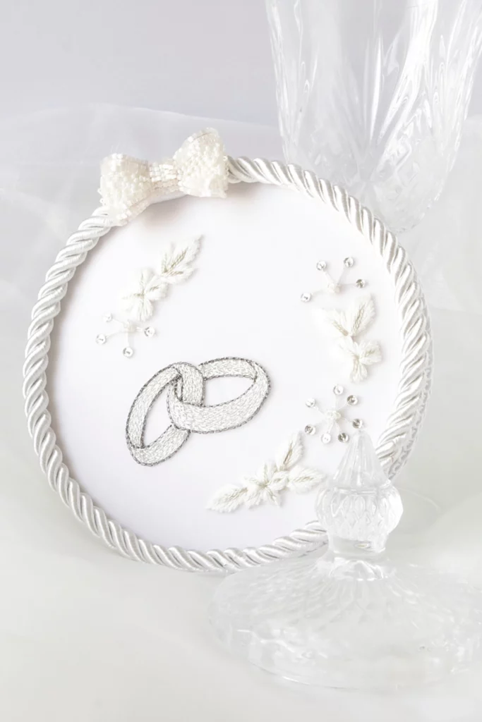 Elegant wedding ring holder with custom embroidery, personalized to match the bride's dress for a unique an elegant creation.