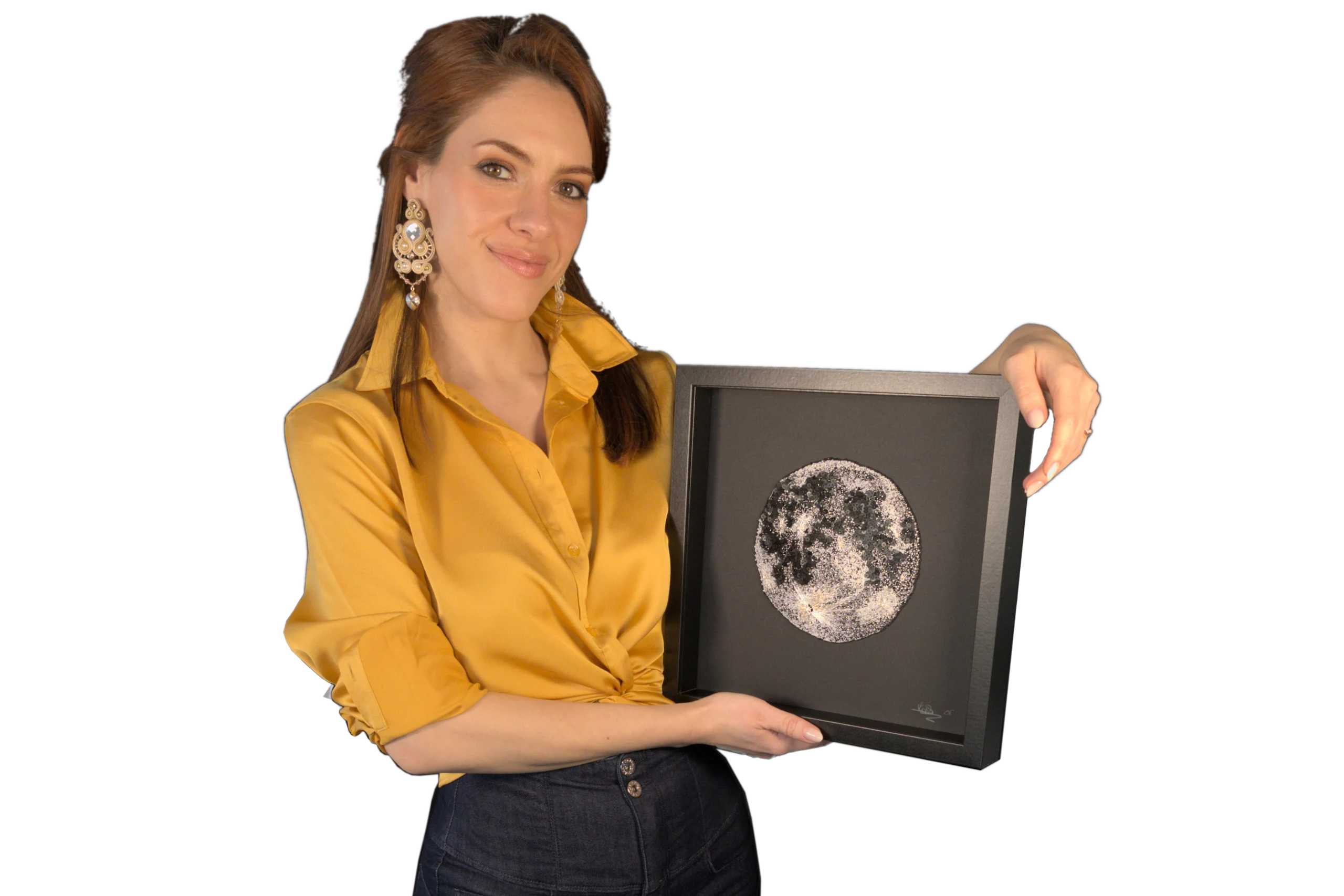 Laura S. Urbina tient une œuvre d'art entièrement brodée à la main représentant la Lune, encadrée en noir.