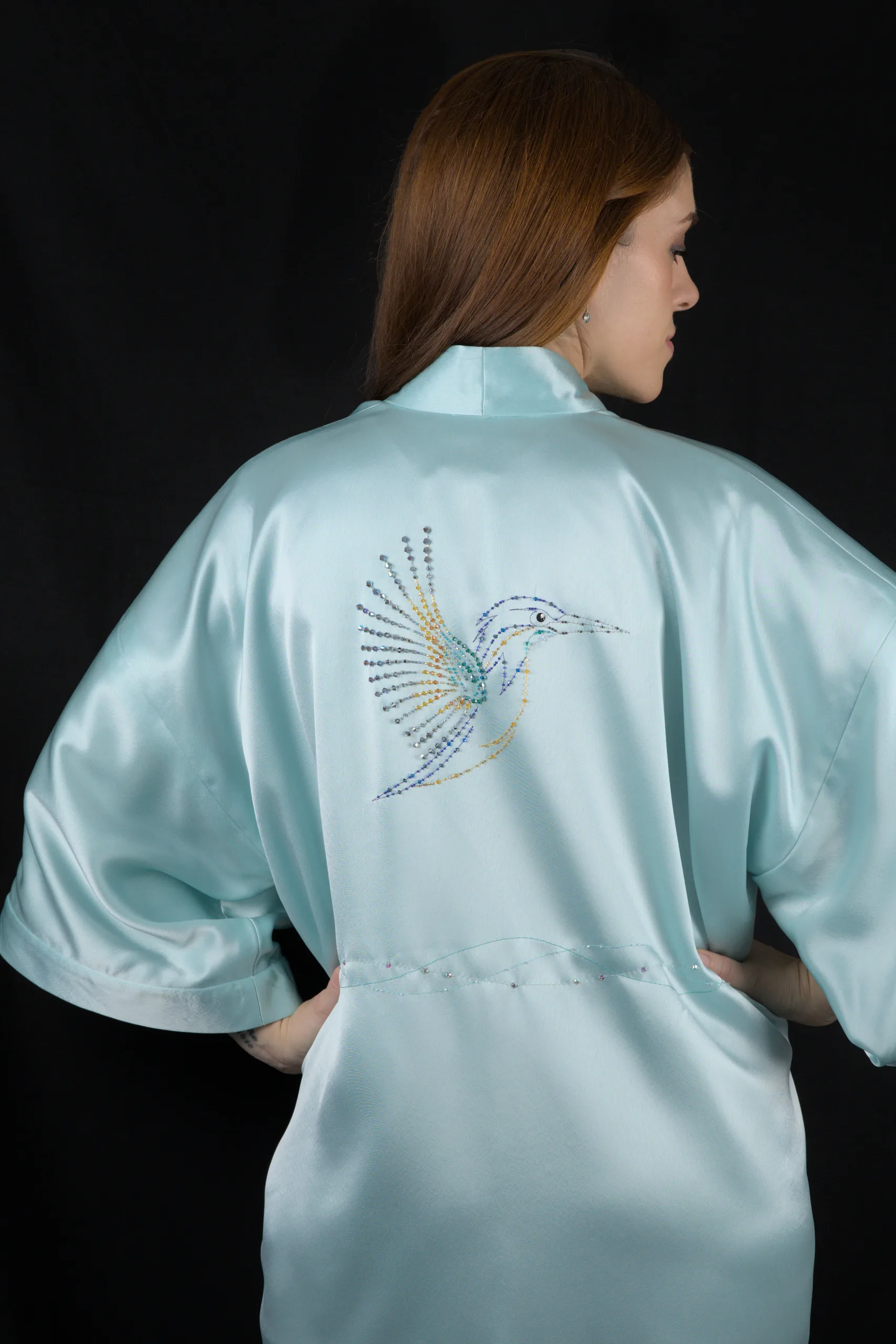 Modelo con el kimono Alcyone turquesa luciendo el martín pescador bordado con cristales en la espalda.