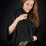 Modelo con la bufanda Celaeno de cachemira negra y su discreta cuadrícula bordada a mano.