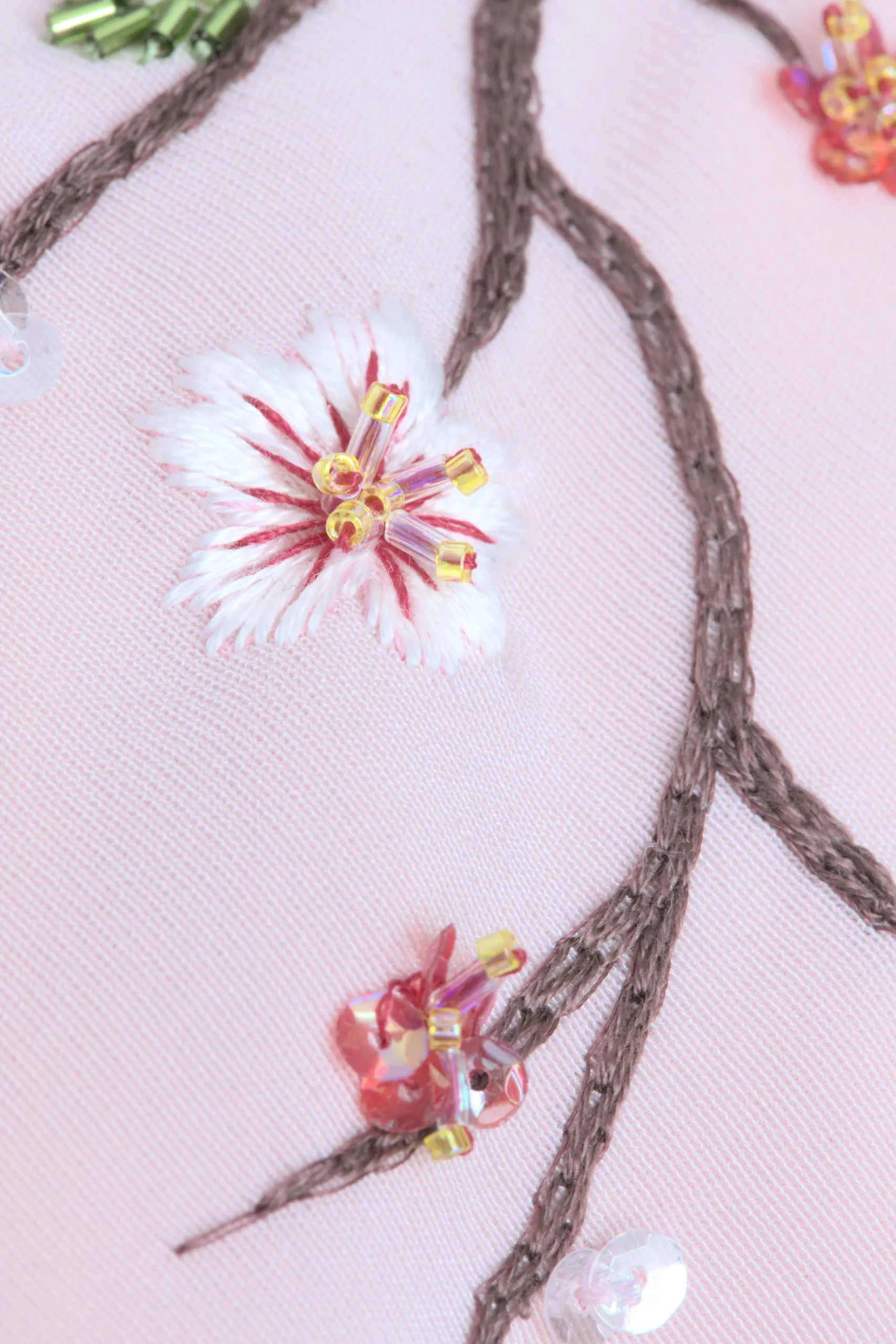Close up shot of the Maia kimono, hand-embroidered cherry blossom branch, Pleiades collection.