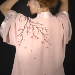 Modelo de espalda con el kimono rosa Maia y su rama con flores de cerezo bordadas a mano.