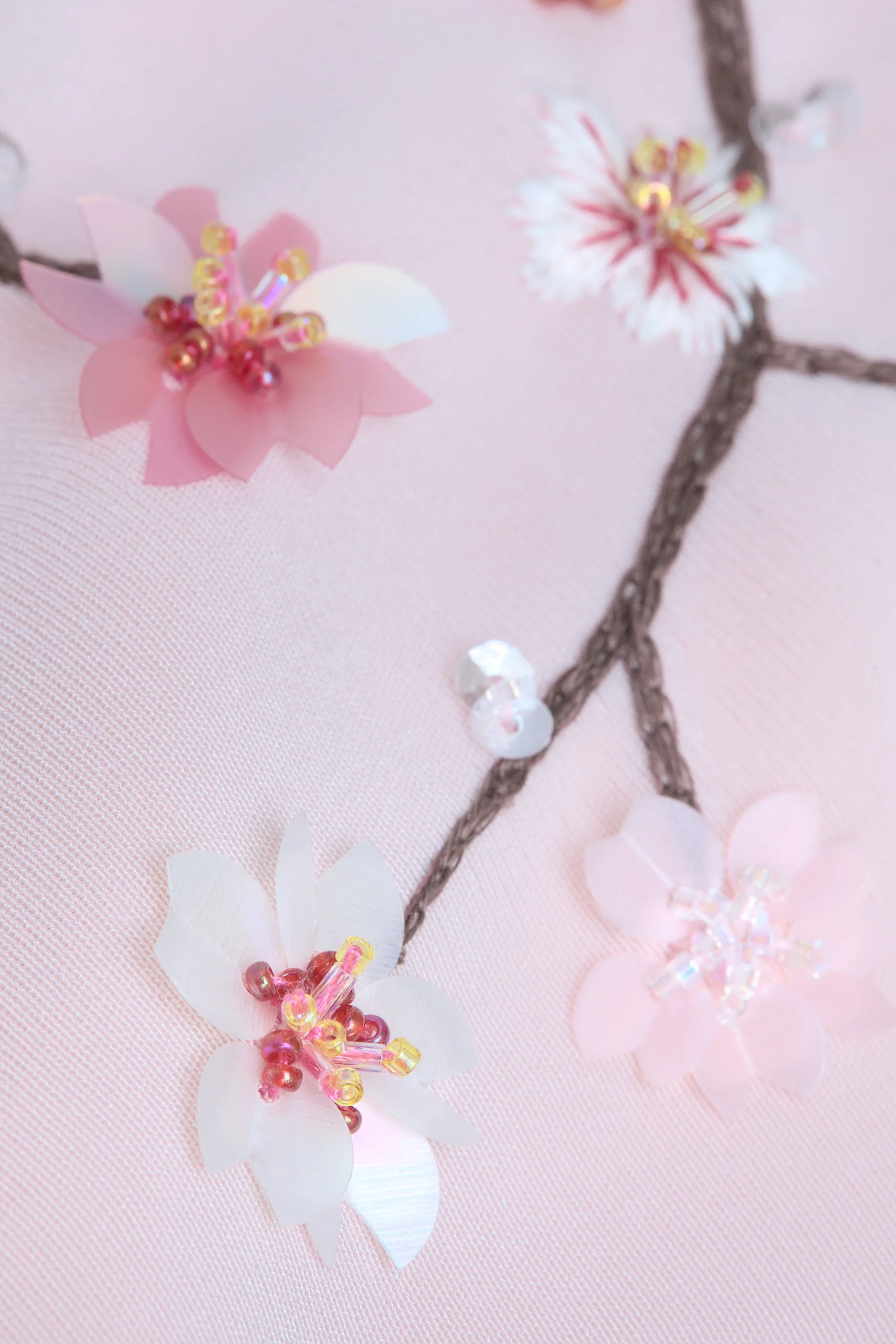 Primer plano del bordado de las flores de cerezo del kimono Maia, estrella de las Pléyades.