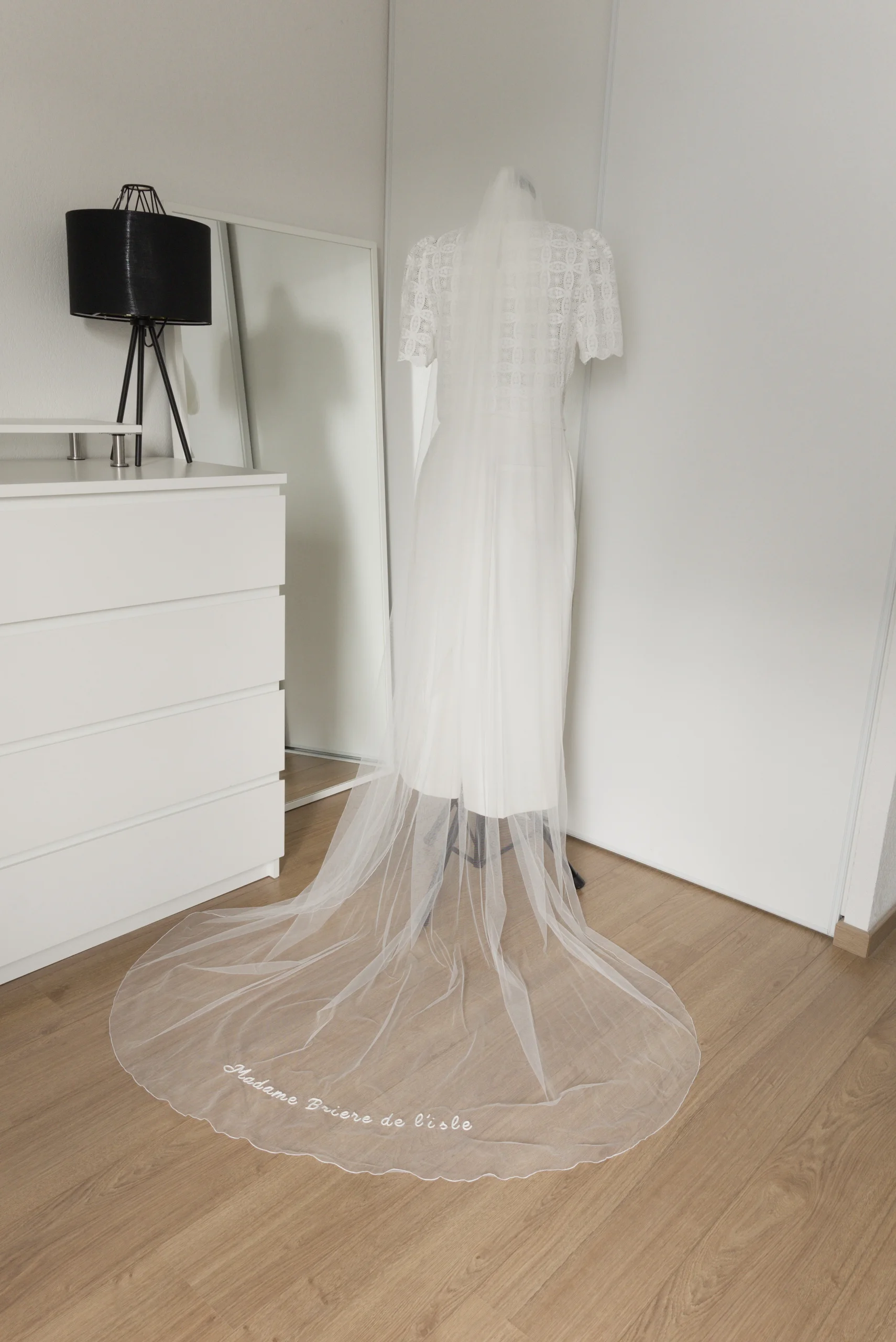 Minimalist embroidered bridal veil displayed on a mannequin in the embroidery studio, showing its delicate personalised detail.