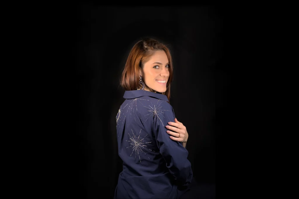 Retrato de Laura S. Urbina con una camisa bordada por ella misma, mostrando el bordado como forma de autoexpresión creativa y arte textil.